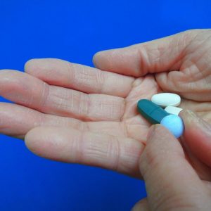 mens health photo 1 2 close up mans hand holding pills in his right palm and picking up one blue pill t20 loE93g 300x300 1